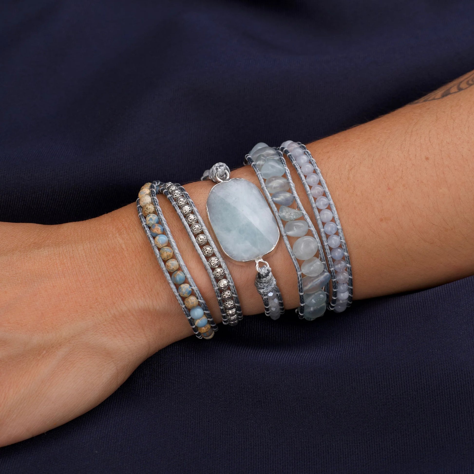 Pulseira de pedras naturais Maré com Água Marinha, Angelita e Jaspe Imperial no pulso, destacando seu design artesanal em tons de azul.